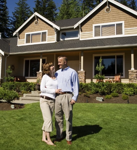 Man and woman in front of their home