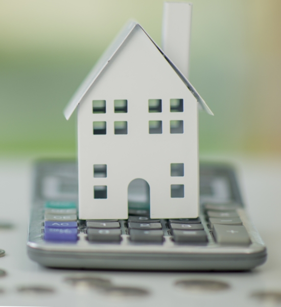 House figurine sitting on a calculator