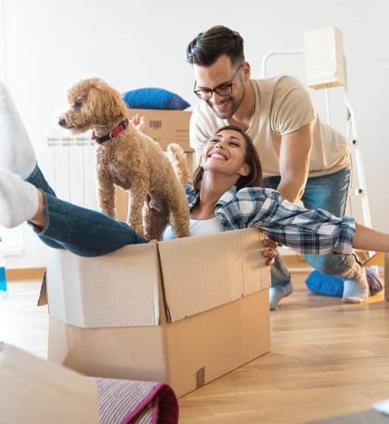 Man, dog, and woman enjoying unpacking