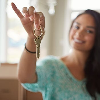 woman smiling and holding a set of keys