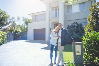 Man and woman standing by house number 