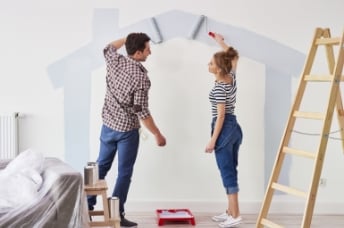 Man and woman painting walls 