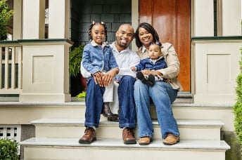 Family sitting on steps of porch 