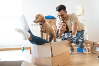 Man, dog, and woman enjoying unpacking 