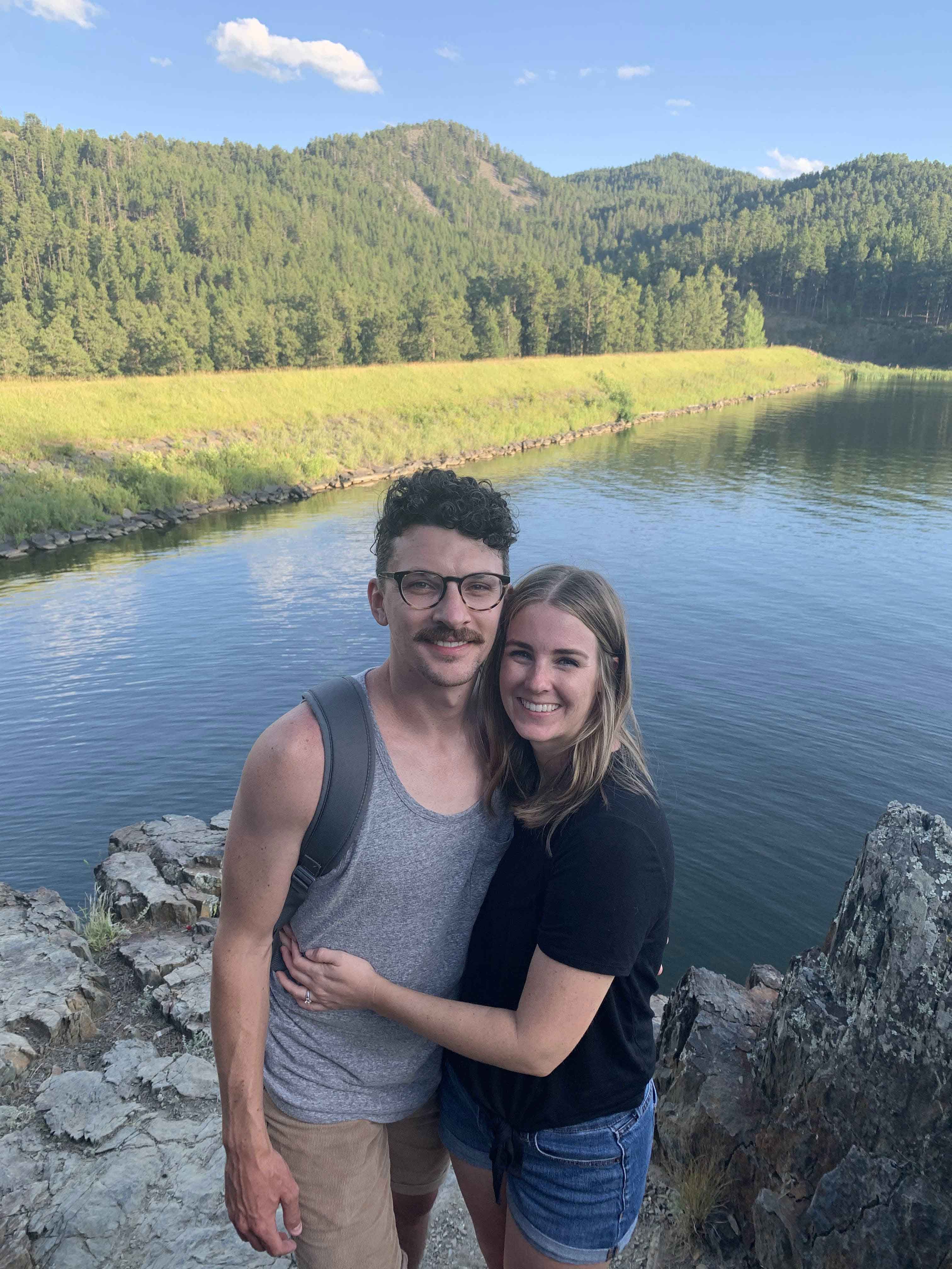 Amanda and her partner in front of a lake.