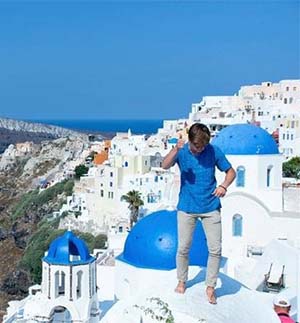 Heath posing on blue and white building in Greece